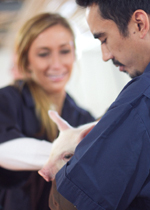 Pair holding piglet.