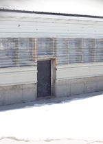 A wintry yard outside a pig actuated door.