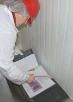 A Truebridge evaluator checking a binder filled with specification sheets.